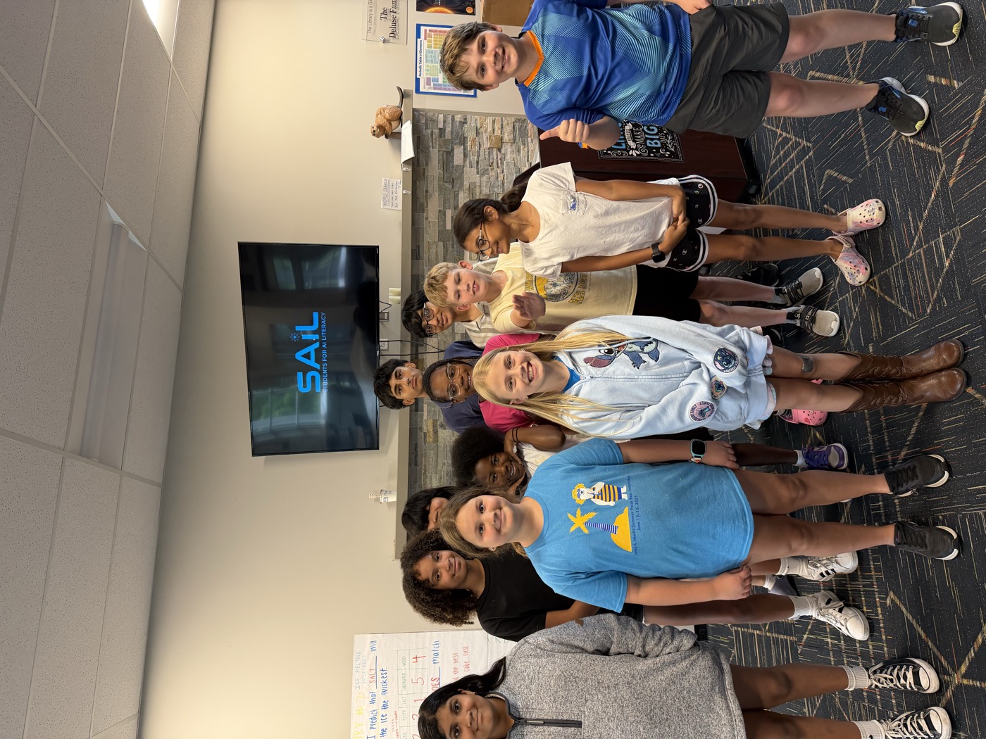 Participants smiling together beneath the SAIL Students For AI Literacy screen